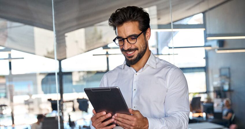 Business man using tablet standing in office