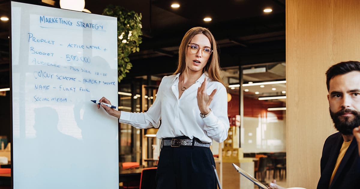 Woman presenting a marketing strategy in a whiteboard
